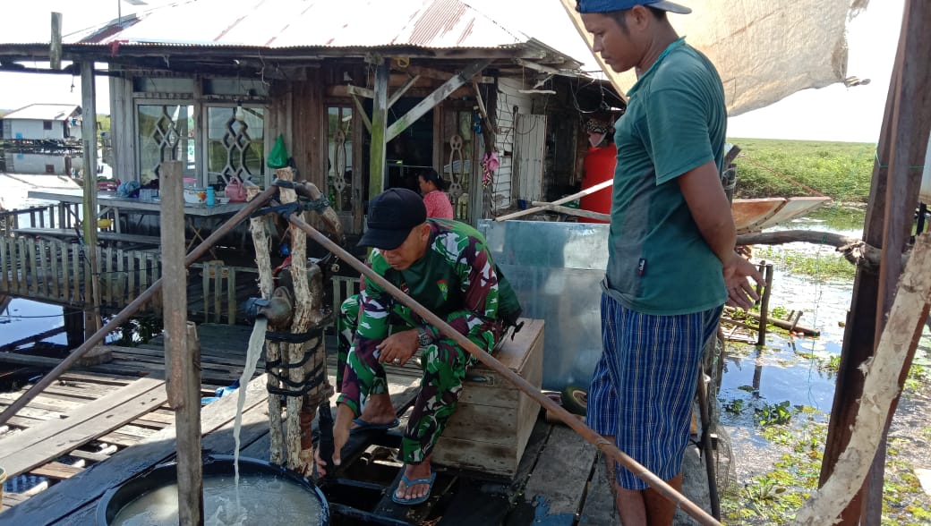 Babinsa bersama warga saat memperbaiki pompa air di Dusun Awang Landas HST yang rusak.