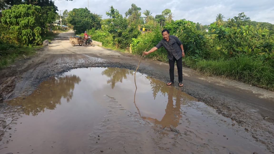 Anggota DPRD Tala Sarjana saat memperlihatkan jalan rusak di Desa Batu Mulya, Kecamatan Panyipatan, Kabupaten Tanah Laut.