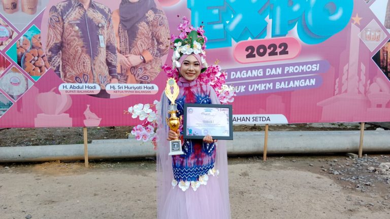 Anggi memegang piala kemenangan Putri anggrek. (Rins)