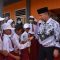 Bupati Kapuas Ben Brahim S Bahat saat bersalaman dengan para murid SD yang ikut menghadiri Peringatan HUT ke-77 PGRI)dan Hari Guru Nasional ( Foto HMS)