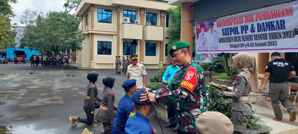 Dandim 1002/HST Letkol Kav Gagang Prawardhana, saat memasangkan baret kepada perwakilan anggota Satpol PP dan Damkar HST. Foto: ID / LK