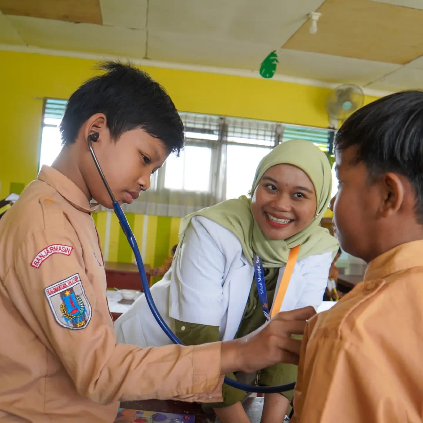Keseruan Relawan Inspirator Kelas Inspirasi 5 Banjarmasin bersama para siswa saat memberikan kesempatan untuk mencoba alat peraga kedokteran.