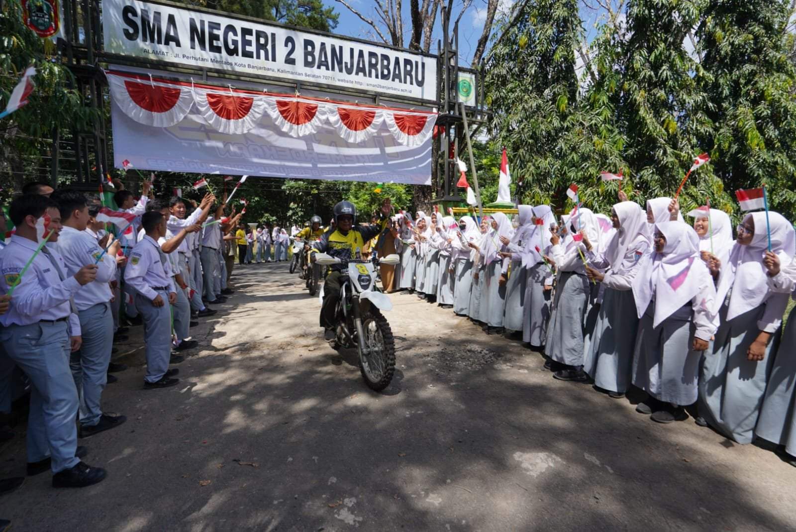 Paman Birin disambut para siswa dan siswi SMAN 2 Banjarbaru sembari mengibarkan bendera merah putih.