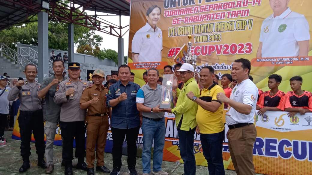 Pj Bupati Tapin M Syarifudin MPd saat menyerahkan tropy juara turnamen sepakbola kepada Kepala SMPN 1 Salam Babaris yang keluar sebagai juara 1 turnamen BRE CUP V. Foto: Dispora Tapin