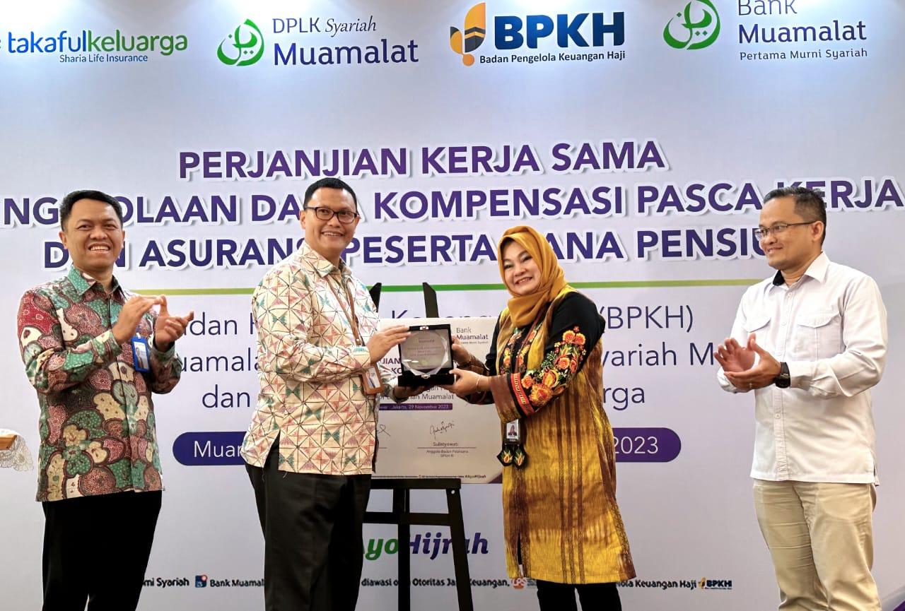 Pelaksana Tugas Pengurus Utama DPLK Syariah Muamalat Kadar Budiman (kedua kiri) menyerahkan plakat kepada Anggota Badan Pelaksana Badan Pengelola Keuangan Haji (BPKH) Sulistyowati (kedua kanan) disaksikan oleh Direktur Keuangan dan Strategi PT Bank Muamalat Indonesia Tbk Suhendar (kiri) dan Deputi SDM, Pengadaan dan Umum BPKH Miftahudin (kanan) pada seremoni kerja sama pengelolaan dana dan asuransi peserta dana pensiun di Jakarta, Rabu (29/11). Foto: Abdurahman