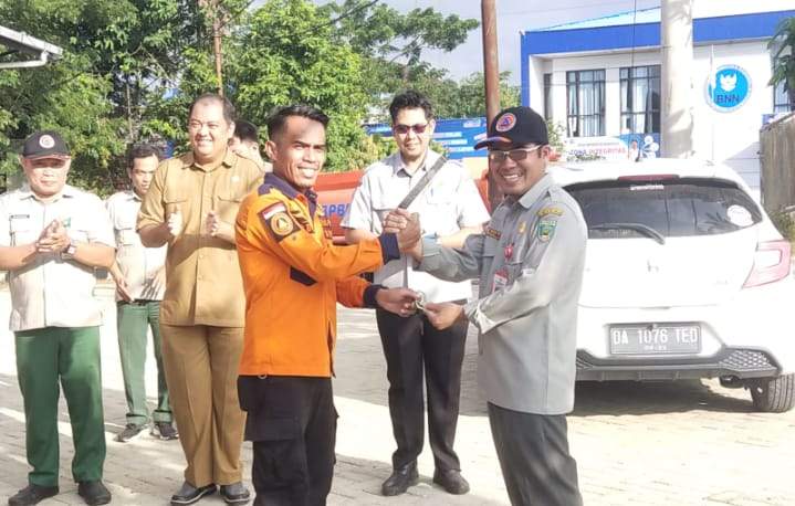 Kalak BPBD Balangan H. Rahmi saat menyerahkan kunci atau fasilitas lapangan berupa kendaraan Trail kepada Roby Ketua TRC baru di halaman kantor BPBD setempat. Foto: TRC Balangan