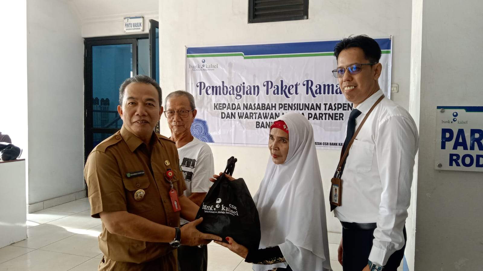 PJ Bupati Tapin M Syarifuddin saat menyerahkan bantuan sembako kepada salah satu penerima manfaat