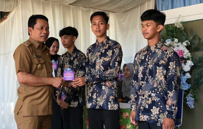 Bupati Balangan Abdul Hadi saat menyerahkan cinderamata bagi sejumlah murid MA Darussalam Awayan di kegiatan perpisahan dan pengukuhan siswa-siswi.Foto: Kominfo Balangan