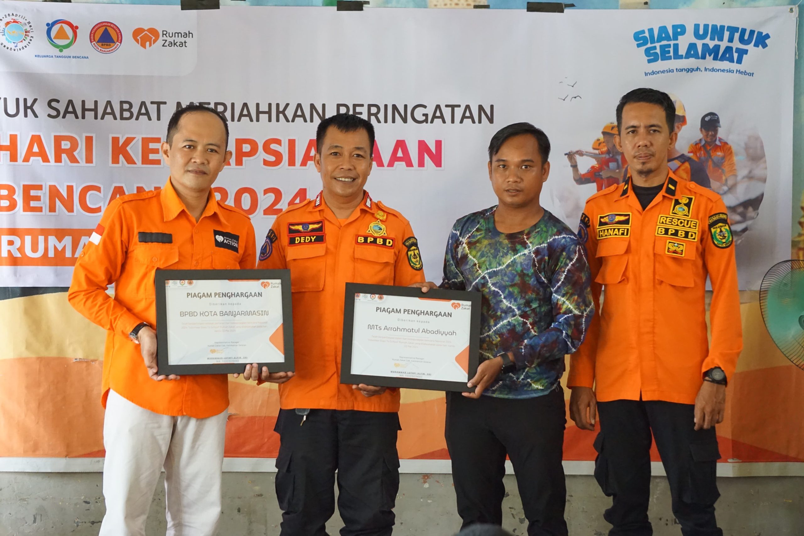 Representative LAZNAS Rumah Zakat kantor perwakilan Provinsi Kalsel, Muhammad Luthfi Alfin serahkan dua piagam penghargaan kepada MTS Arrahmatul Adabiyah dan BPBD Kota Banjarmasin. Kamis (2/5/2024). Foto: Rumah Zakat Kalsel.