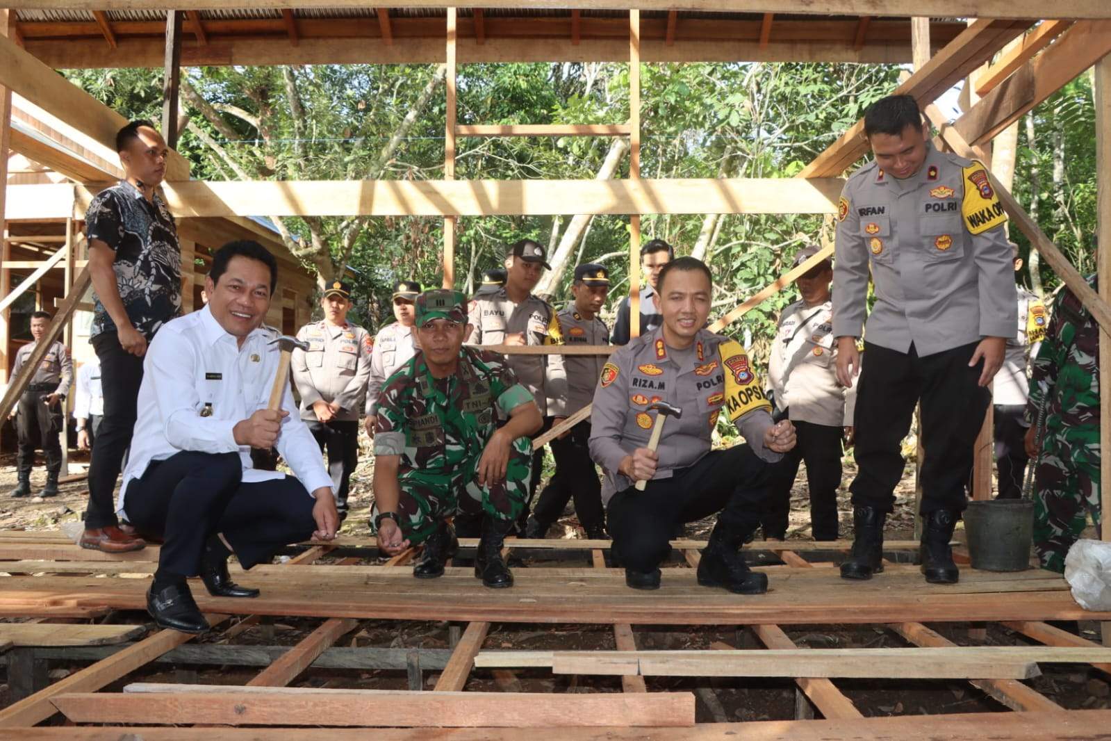 Dibantu pihak lainnya, Kapolres Balangan AKBP Riza Muttaqin bersama Bupati Abdul Hadi, terlihat memegang palu saat proses pengerjaan bedah rumah untuk memberikan kelayakan rumah hunian. Foto: Humas Polres Balangan