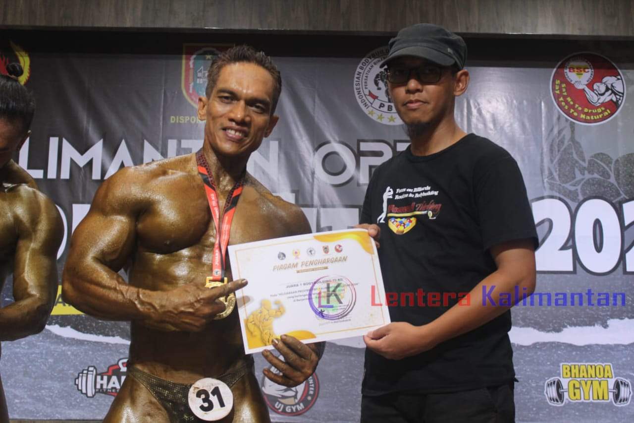Ketua Umum Perkumpulan Binaraga dan Fitnes Indonesia (PBFI) Tanah Laut, Rachmadani saat menyerahkan penghargaan kepada atlet Tanah Laut yang meraih medali emas dalam turnamen Kalimantan Open Body Building Fitness 2024. Minggu (26/5/2024). Foto: Arsyad/lenterakalimnatan.om