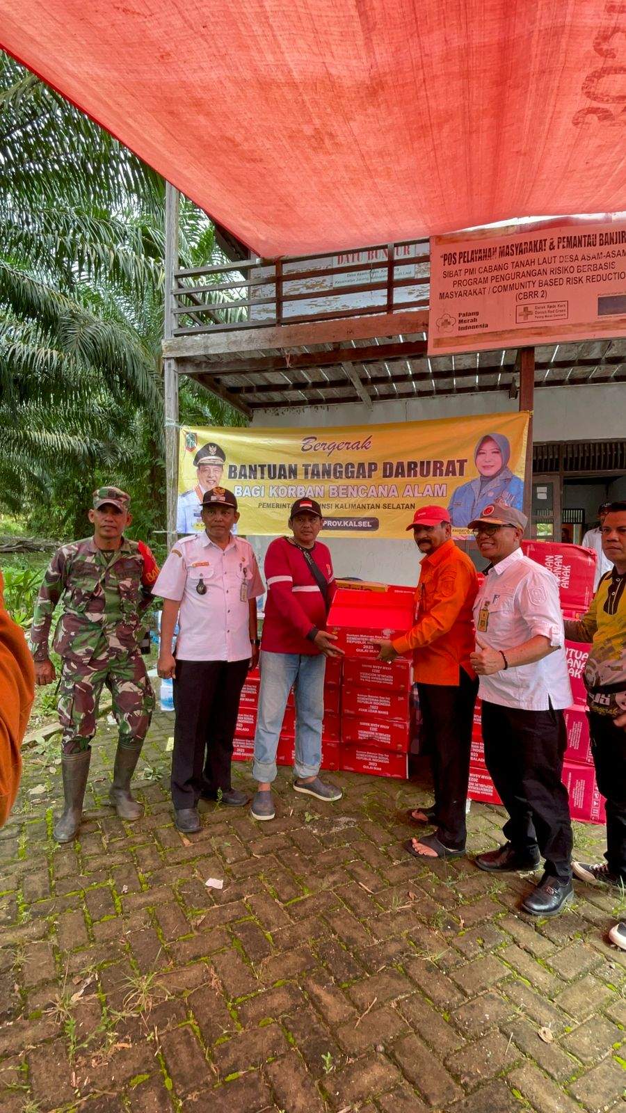 Pj Bupati Syamsir menyerahkan bantuan kepada warga terdampak banjir di Desa Asam-Asam, Jorong, Tanah Laut. Foto: Warga Desa Asam-Asam