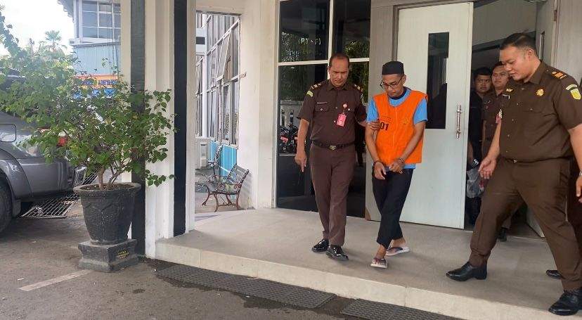 Tersangka korupsi kredit Topengan berinisial HPH menggunakan rumpi orange saat akan dibawa ke LP Teluk Dalam Banjarmasin. Foto: Kejati Kalsel