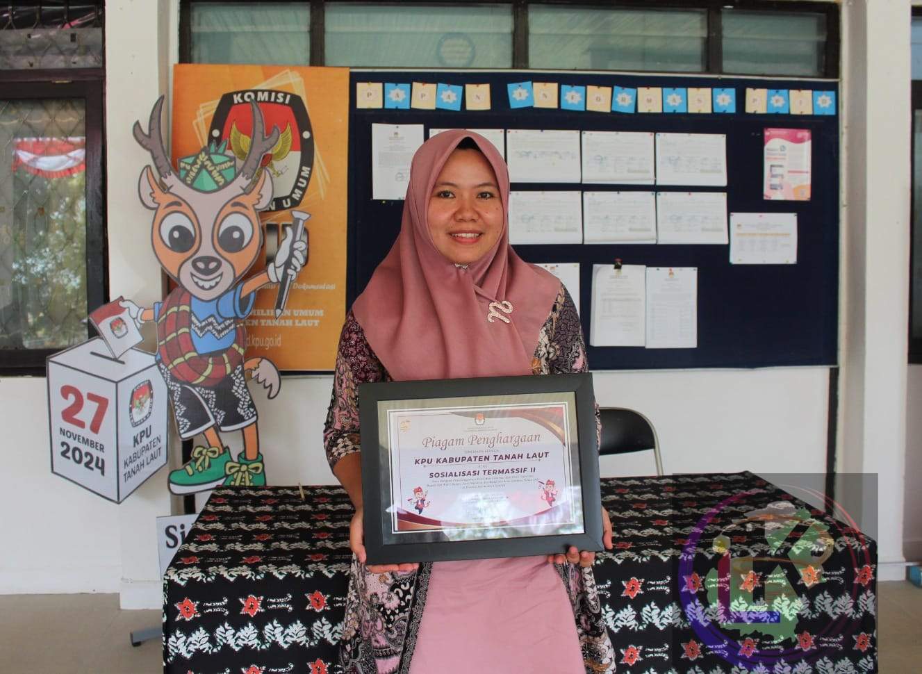 Nina Marta Sintia Koordinator Divisi Sosialisasi Pendidikan Pemilih, Partisipasi Masyarakat dan Sumber Daya Manusia, memegang penghargaan. Foto: dok. Asep/lenterakalimantan.com
