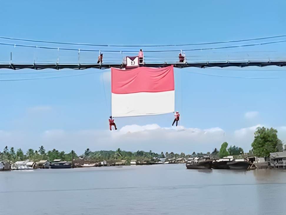 Sang Saka Merah Putih berukuran 400x600 cm berkibar di Jembatan Pulau Bromo, Mantuil, Banjarmasin Selatan, Rabu (14/8/24). Foto: BPBD Kota Banjarmasin