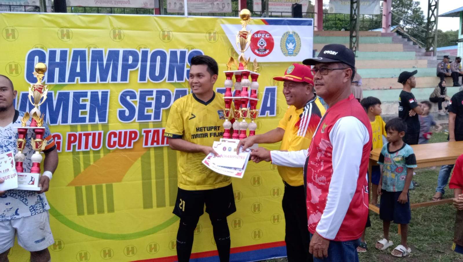 Ketua KONI Tapin H Misran dan Kepala Desa Miawa H Ahmad saat menyerahkan tropy juara.