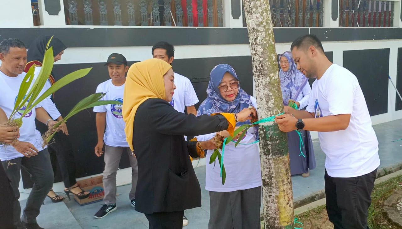 Pj Bupati Hj Hamida Munawarah bersama Ketua DPD PAI Kalsel, Arida Dian Susanti memasang bunga anggrek di pohon. Foto: JM/lenterakalimantan.com
