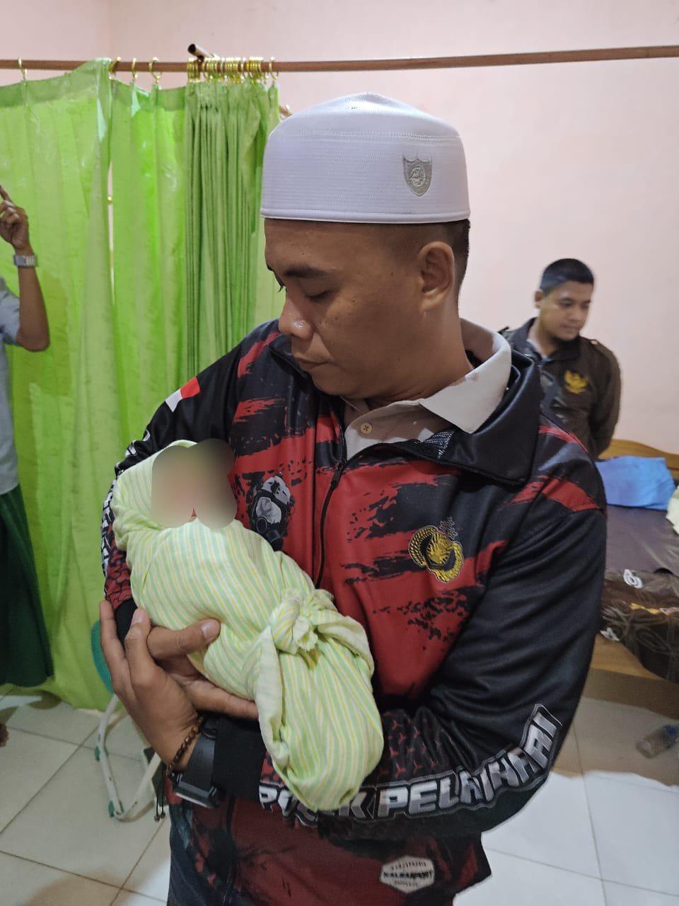 Kapolsek Pelaihari Iptu Benny Wishnu Wardhany, menggendong bayi perempuan setelah dilakukan perawatan. Foto: Polsek Pelaihari