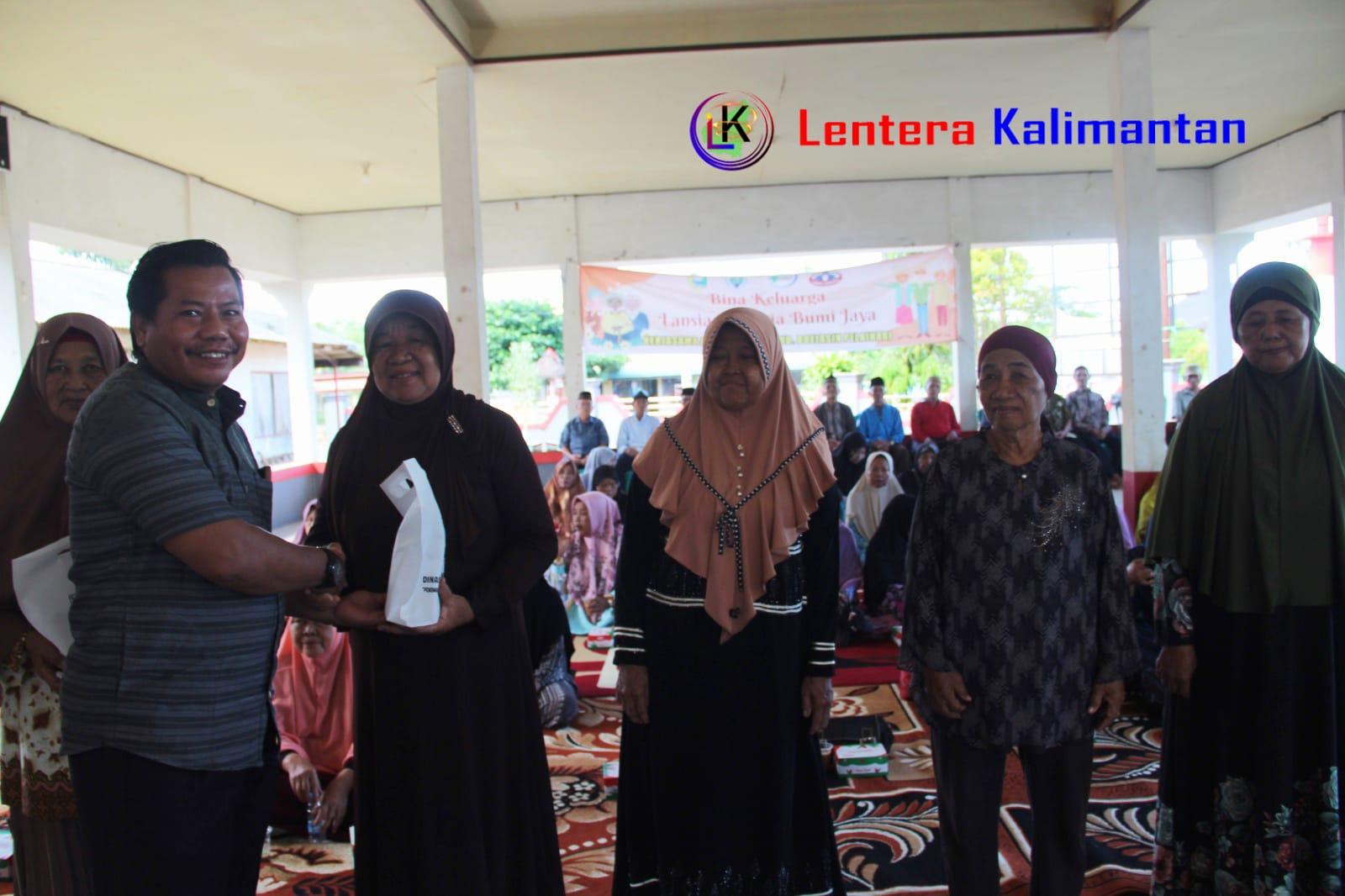 Kepala Desa Bumi Jaya Mulyono menyerahkan bingkisan kepada Lansia yang mengikuti Penkes. Foto: Asep/lenterakalimantan.com