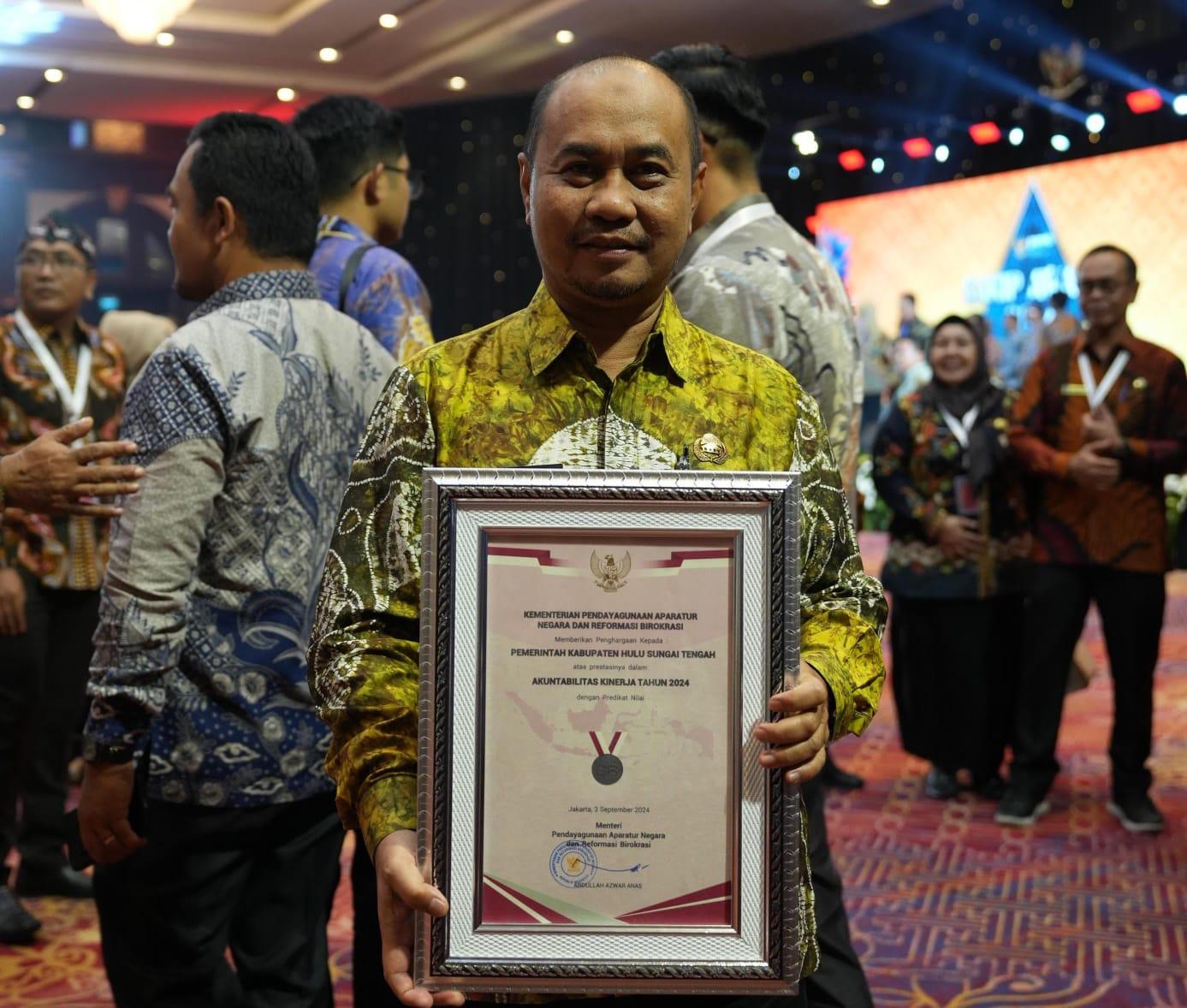 Pjs Bupati HST H Faried Fakhmansyah saat menerima penghargaan predikat BB pada SAKIP Award 2024. Foto: Humas Bupati HST