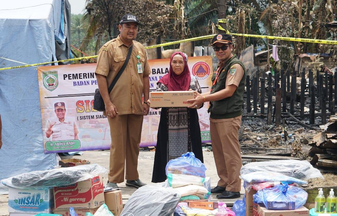 Kepala Pelaksana (Kalak) BPBD Balangan, Rahmi, saat menyerahkan bantuan logistik secara simbolis kepada salah satu korban kebakaran di Desa Buntu Karau, Kecamatan Juai. Foto: BPBD Balangan, untuk lenterakalimantan.com