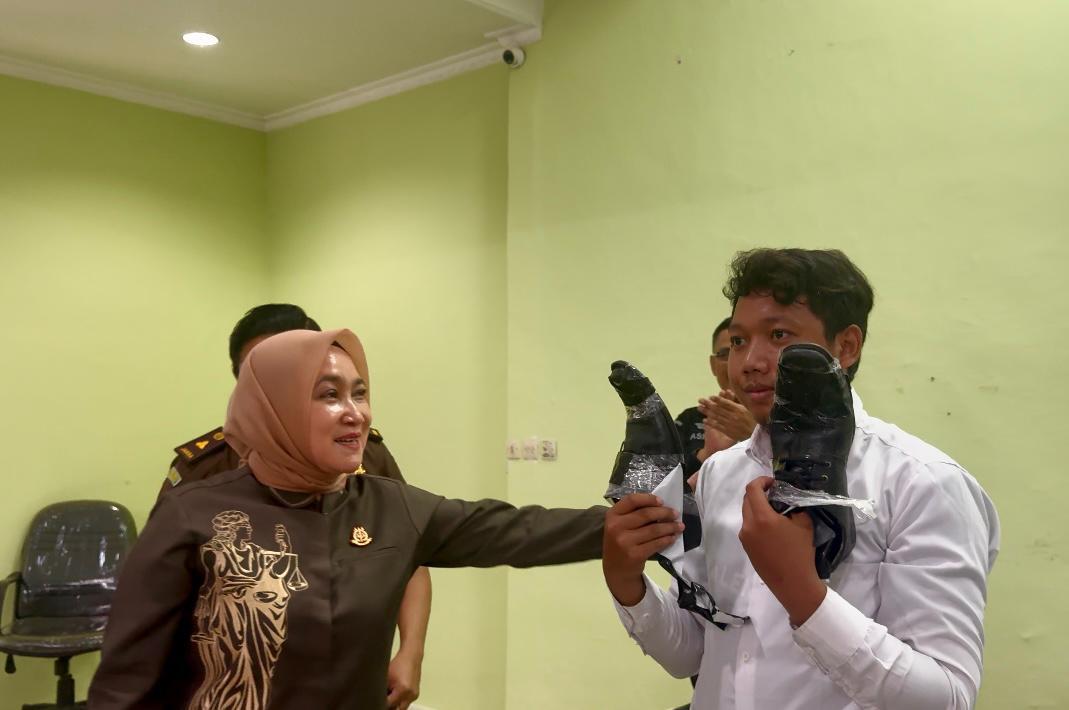 Kajati Kalsel Rina Virawati SH MH saat memberikan sepatu kepada seorang peserta calon CPNS. Foto: Kejaksaan Tinggi RI