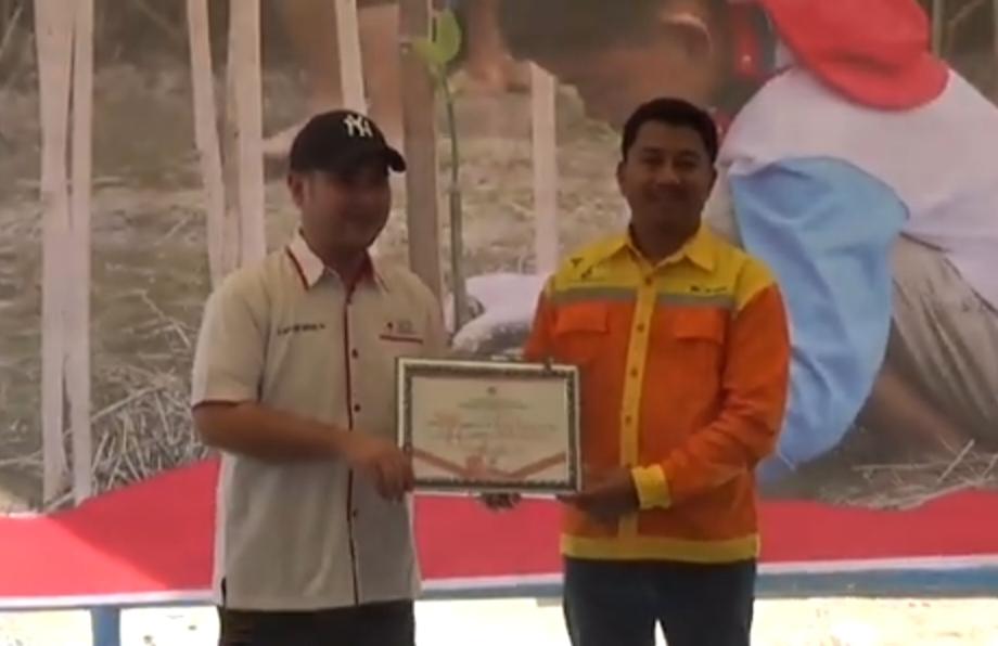 Ketua PMI Tapin H Dedi Arif Budiman saat memberikan penghargaan kepada PT.Bhumi Rantau Energi yang diterima Zulkifli Hasan selaku Corporate Affairs Section Head PT.BRE.