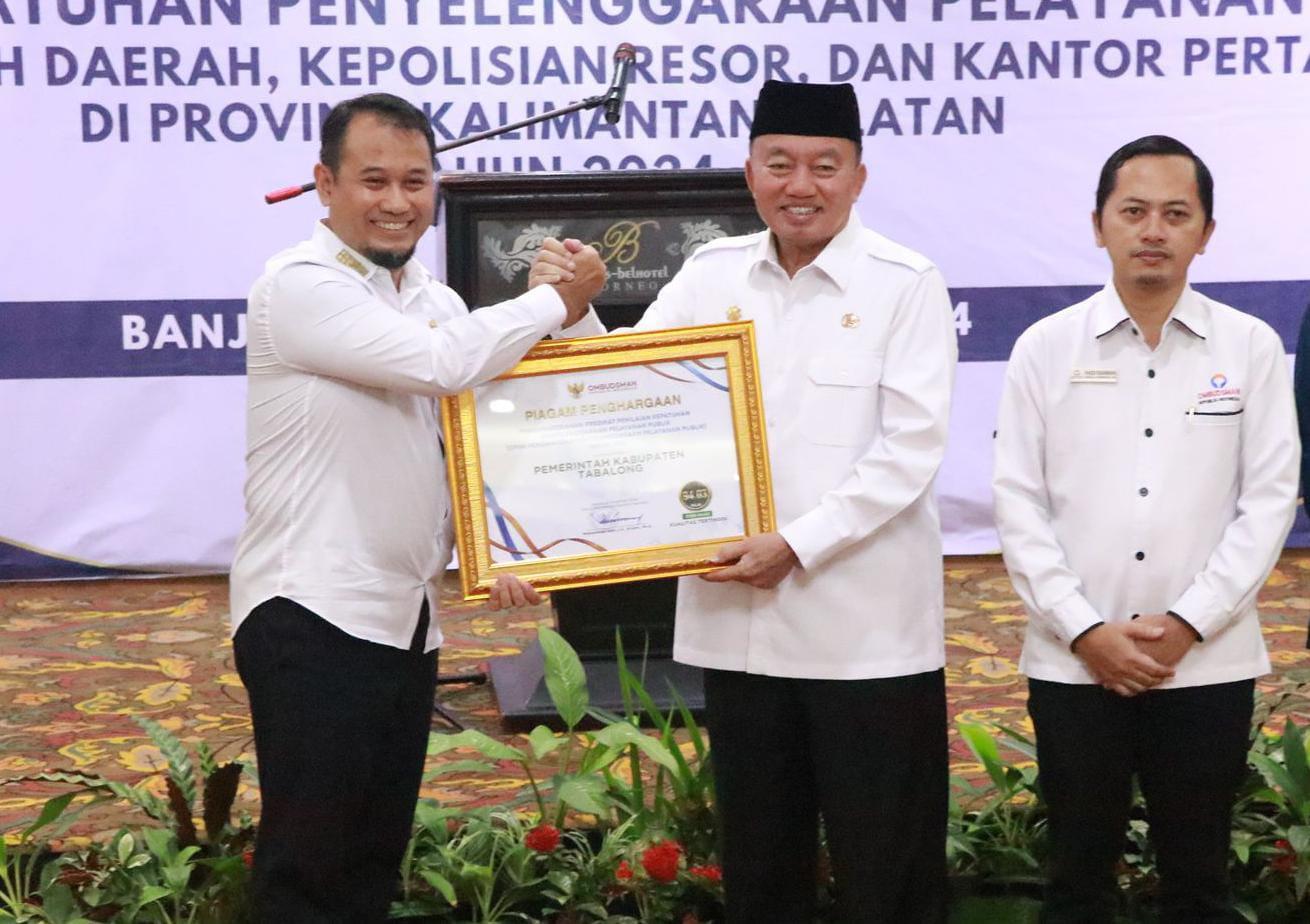 Pj Sekda Tabalong, M Fitri Hernadi menerima piagam penghargaan dari Plt Gubernur Kalsel, H Muhidin. Foto: Diskominfo Tabalong