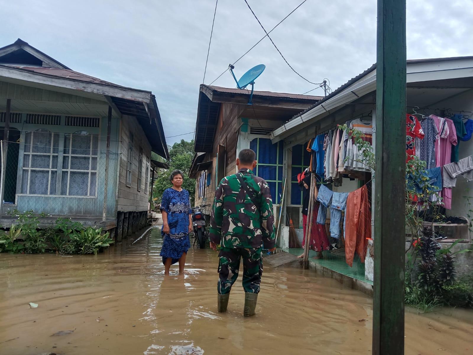 Babinsa 1001-02 Paringin, Sertu Zulkarnain saat berdialog dengan salah seorang warga yang terdampak banjir, di Kelurahan Batu Piring, Paringin Selatan, Balangan, Kalsel. Foto: Pendim 1001/HSU-BLG