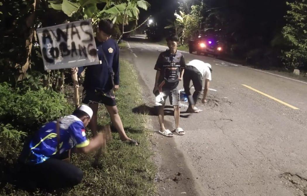 Sejumlah relawan di Balangan, saat menandai jalan yang berlobang dengan cat semprot, serta memasang tanda peringatan jalan yang berlubang. Foto: MC Balangan