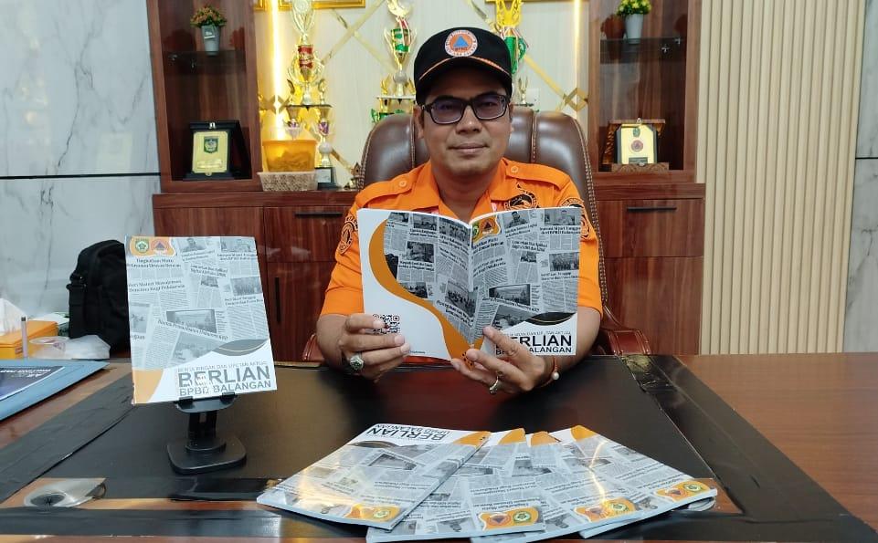 Kalak BPBD Balangan, Rahmi, saat memperlihatkan Buku Berlian yang diterbitkan oleh BPBD Balangan, di ruang kerjanya. Foto: MC Balangan