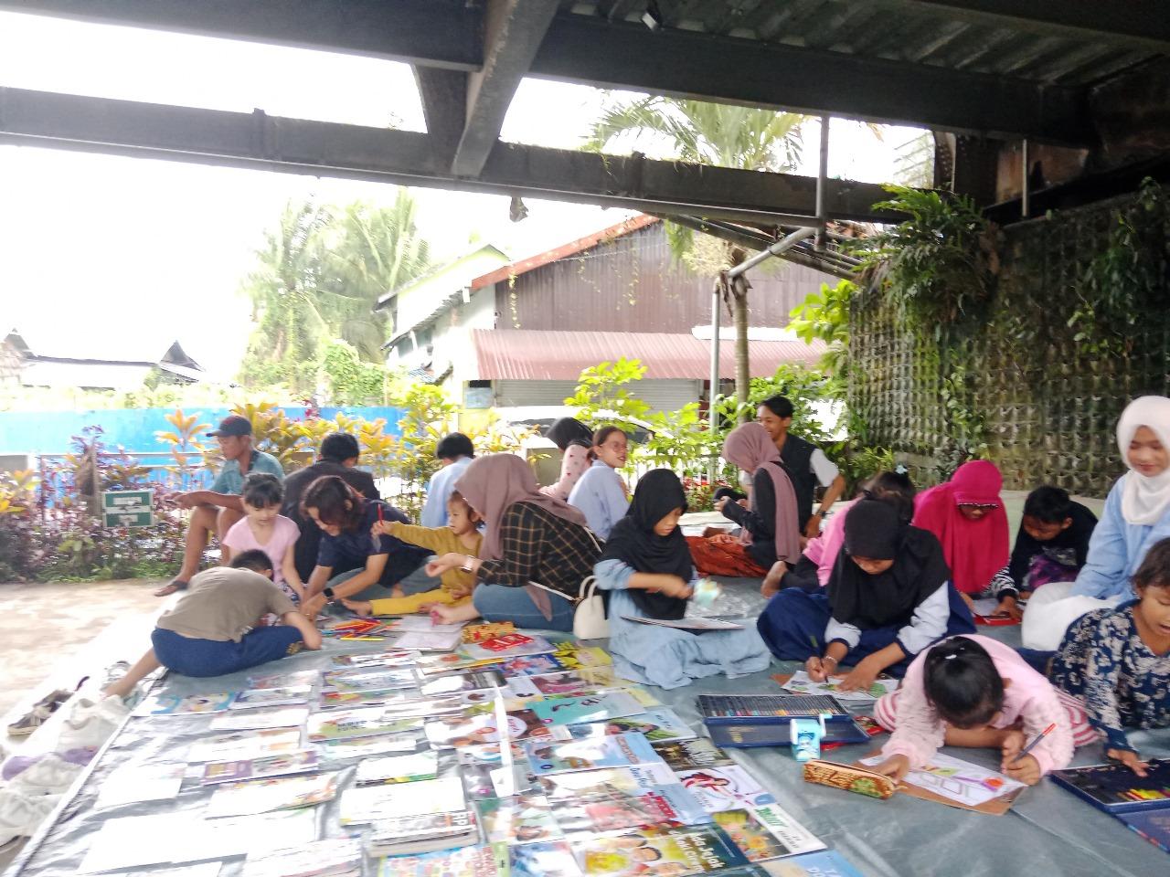 Relawan dan anak-anak sedang asyik membaca dan mewarnai di lapak Sekolah Rakyat Merdeka Kalsel cabang Banjarmasin di Ruang Publik Terpadu Ramah Anak Banua Anyar (RPTA). Foto: Relawan Rakyat Merdeka Kalsel