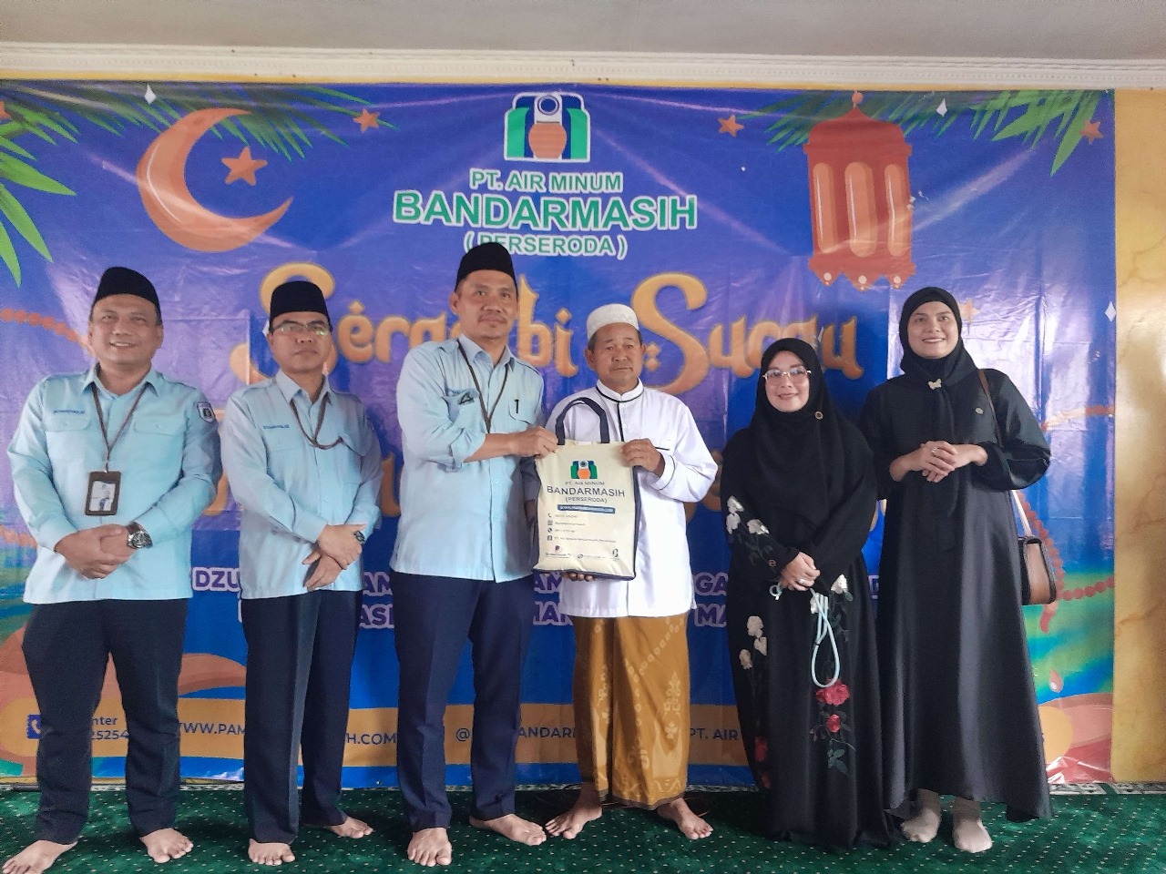 Direktur Utama PAM Bandarmasih, Muhammad Ahdiat, beserta jajaran dan Ketua TP PKK Hj Neli Listriani dan Wakil Walikota Banjarmasin Hj Ananda menyerahkan bantuan 50 paket bapok dan uang tunai di Pelambuan, Banjarmasin Barat. Foto: Pemko Banjarmasin