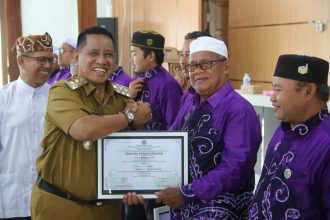 Teks foto//Wabup Zazuli menyerahkan penghargaan kepada guru-guru agama di acara DPD BKPRMI Tala (dok foto Asep LK )