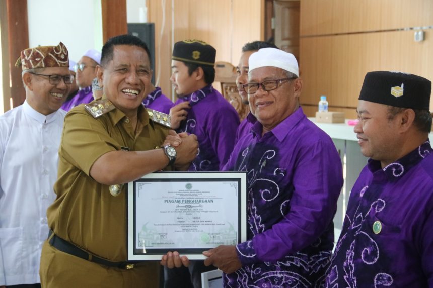 Teks foto//Wabup Zazuli menyerahkan penghargaan kepada guru-guru agama di acara DPD BKPRMI Tala (dok foto Asep LK )