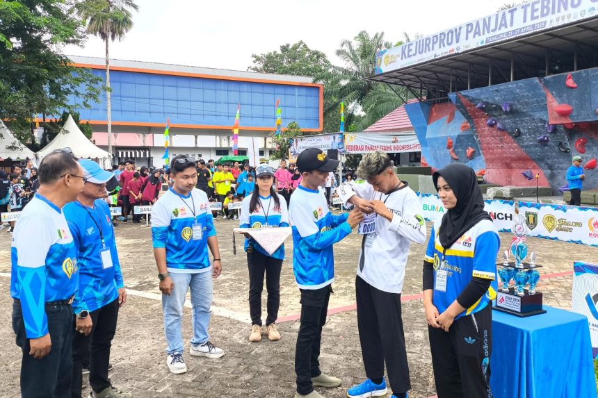 Kepala Disporapar Kabupaten Tabalong, Abdul Halim menyematkan nomor peserta ke salah satu atlet. Foto: JM/lenterakalimantan.com