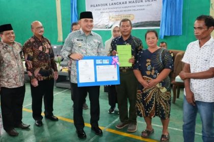 Teks foto/ Bupati Rahmat menyerahkan berkas kepada warga setelah mengikuti program inovatif ini.