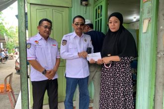 Teks foto : H Edi Sucipto SH MH Ketua DPD organda Kalsel saat menyerahkan santunan kepada isteri korban