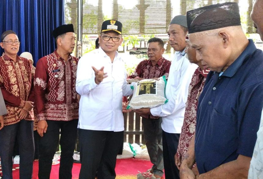 Bupati Tabalong, H M Noor Rifani menyerahkan bantuan beras didampingi Camat Muara Harus, Rudi Noor Erwan. Foto: JM/lenterakalimantan.com