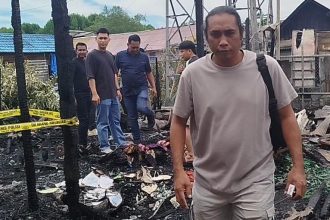 Foto: Suasana saat petugas kepolisian memeriksa lokasi pasca kebakaran di Desa Sejahtera. Sumber Foto: Arif LK.