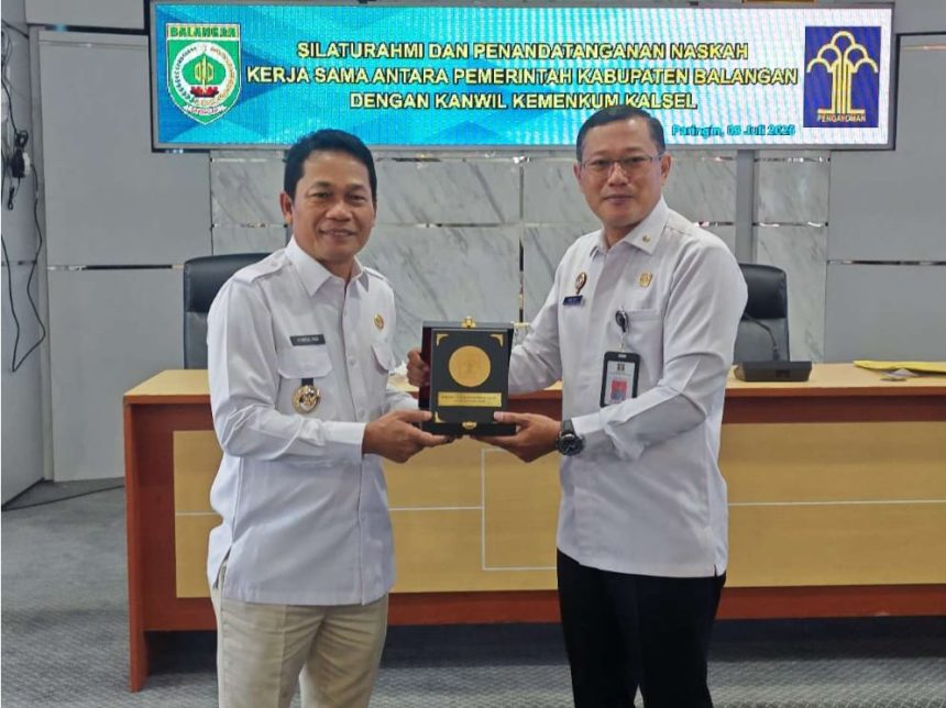 Bupati Balangan, Abdul Hadi, saat menerima plakat kenang-kenangan dari Plt Kepala Kanwil Kemenkumham Kalsel, Meidy Firmansyah, di Kantor Bupati Balangan. Foto: MC Balangan