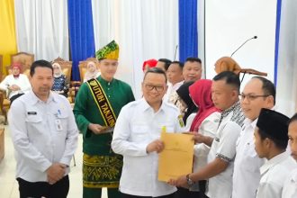 Bupati Tabalong, HM Noor Rifani secara simbolis menyerahkan dokumen pendirian dan pendirian badan hukum koperasi desa dan kelurahan merah putih. Foto: JM