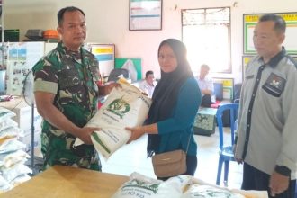 Dok //Aktivitas Babinsa Kodim 1009/TLA Sertu Triyono, Saat pengawalan bantuan Cadangan Pangan Beras (CPB) di Desa Pemuda Kecamatan Pelaihari , Senin (27/07