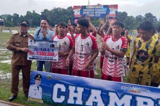 Bupati Kotabaru H. M. Rusli menyerahkan piala dan uang pembinaan kepada para juara Turnamen Sepak Bola Bupati Cup 2025 di Stadion Bamega. Foto: Putri/lenterakalimantan.com)