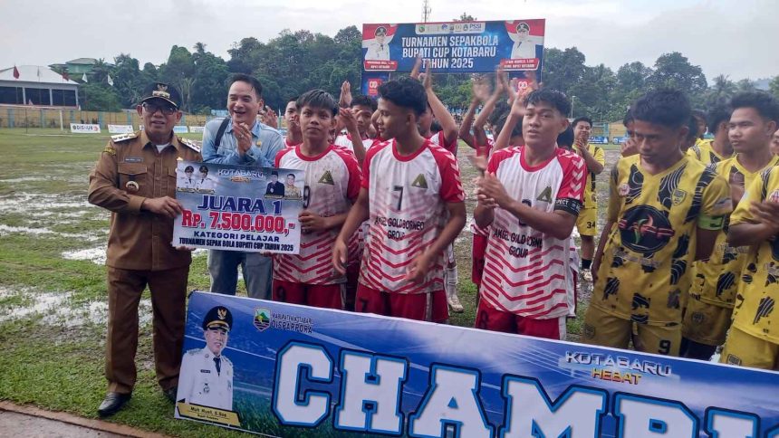 Bupati Kotabaru H. M. Rusli menyerahkan piala dan uang pembinaan kepada para juara Turnamen Sepak Bola Bupati Cup 2025 di Stadion Bamega. Foto: Putri/lenterakalimantan.com)