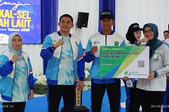 Bupati Tanah Bumbu Andi Rudi Latif secara simbolis menyerahkan Kartu BPJS Ketenagakerjaan kepada perwakilan atlet yang akan mengikuti Porprov. (Sumber foto: Arif LK)