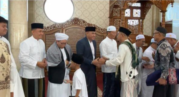 Teks foto/ Bupati Tanah Laut Rahmat Trianto dan DPR RI Endang Agustina bersalaman dengan masyarakat usai salat idul Fitri di Masjid Noor Hasyim ( dok Asep LK )