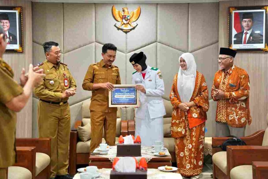 Bupati Banjar H Saidi Mansyur menyerahkan penghargaan berupa paket umrah kepada Siti Nur Adlina yang berhasil menjadi anggota Paskibraka Tingkat Nasional 2026, di Mahligai Sultan Adam Martapura, Senin (24/8/26).